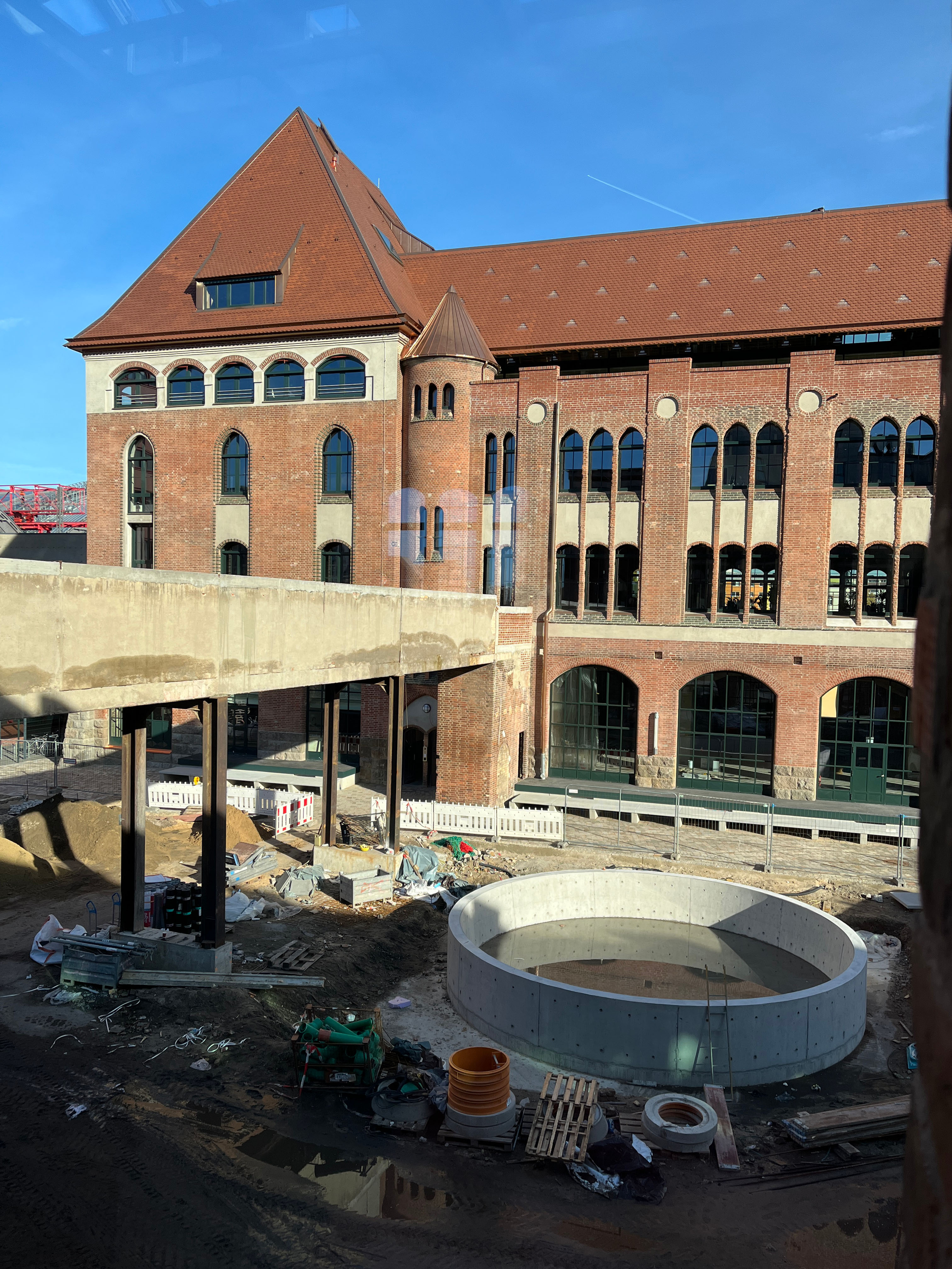 xterior view of construction progress at Postbahnhof Berlin, showing the outdoor area and outdoor office.