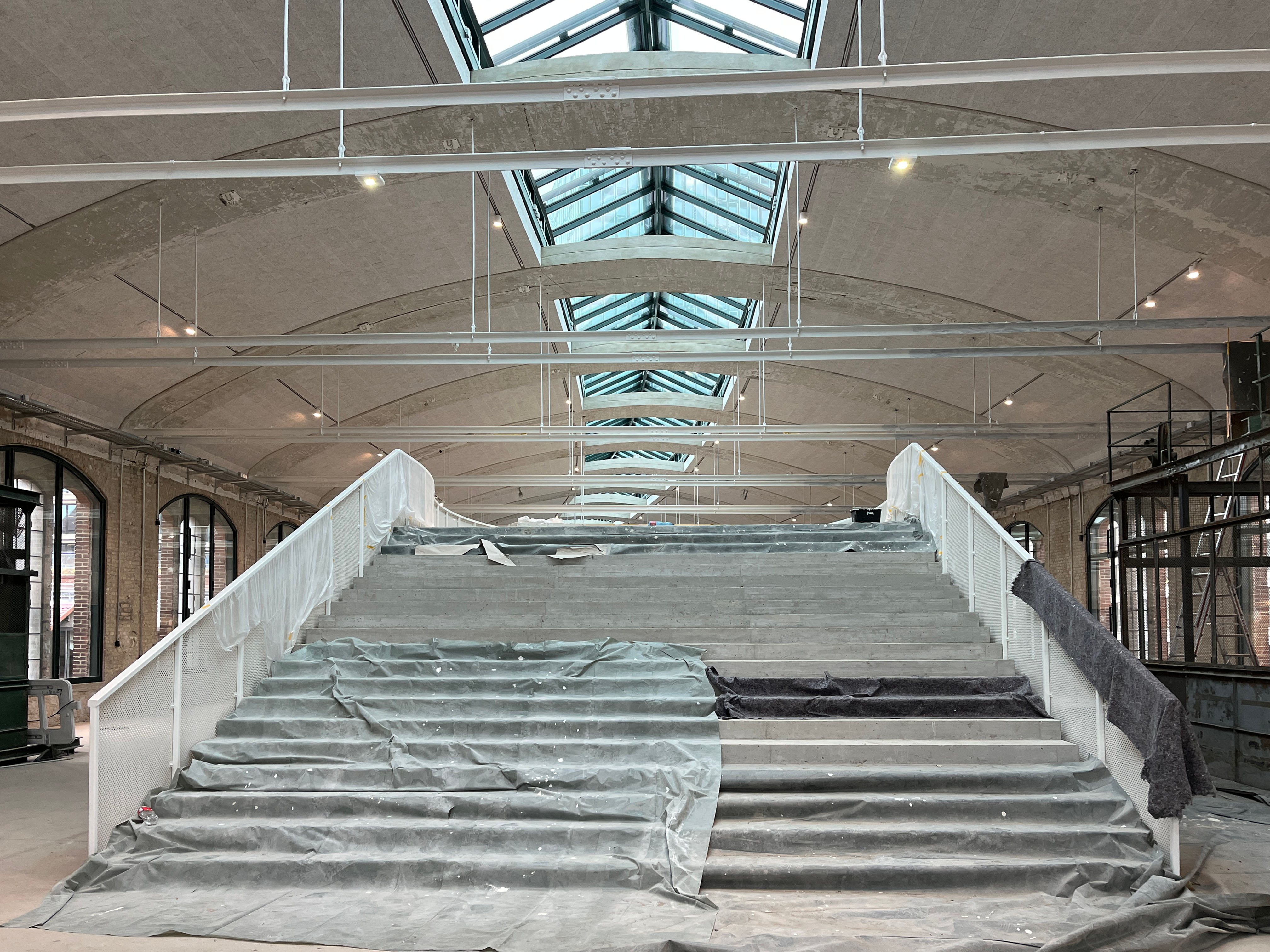 Entrance packing room of the postal station with large staircase and glass roof.