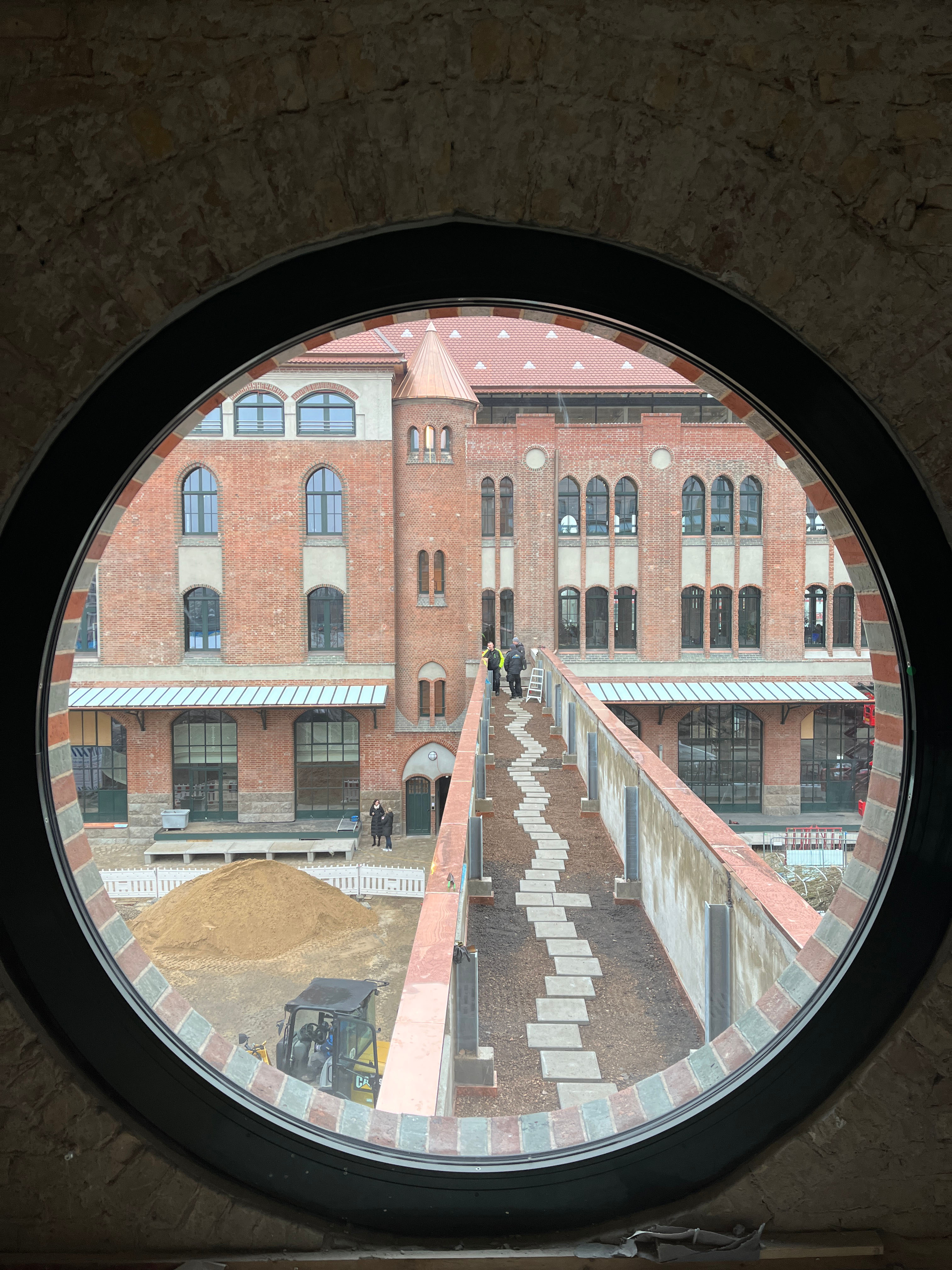 Terrace corridor between the exit packing room and the entrance packing room, captured through a round window.