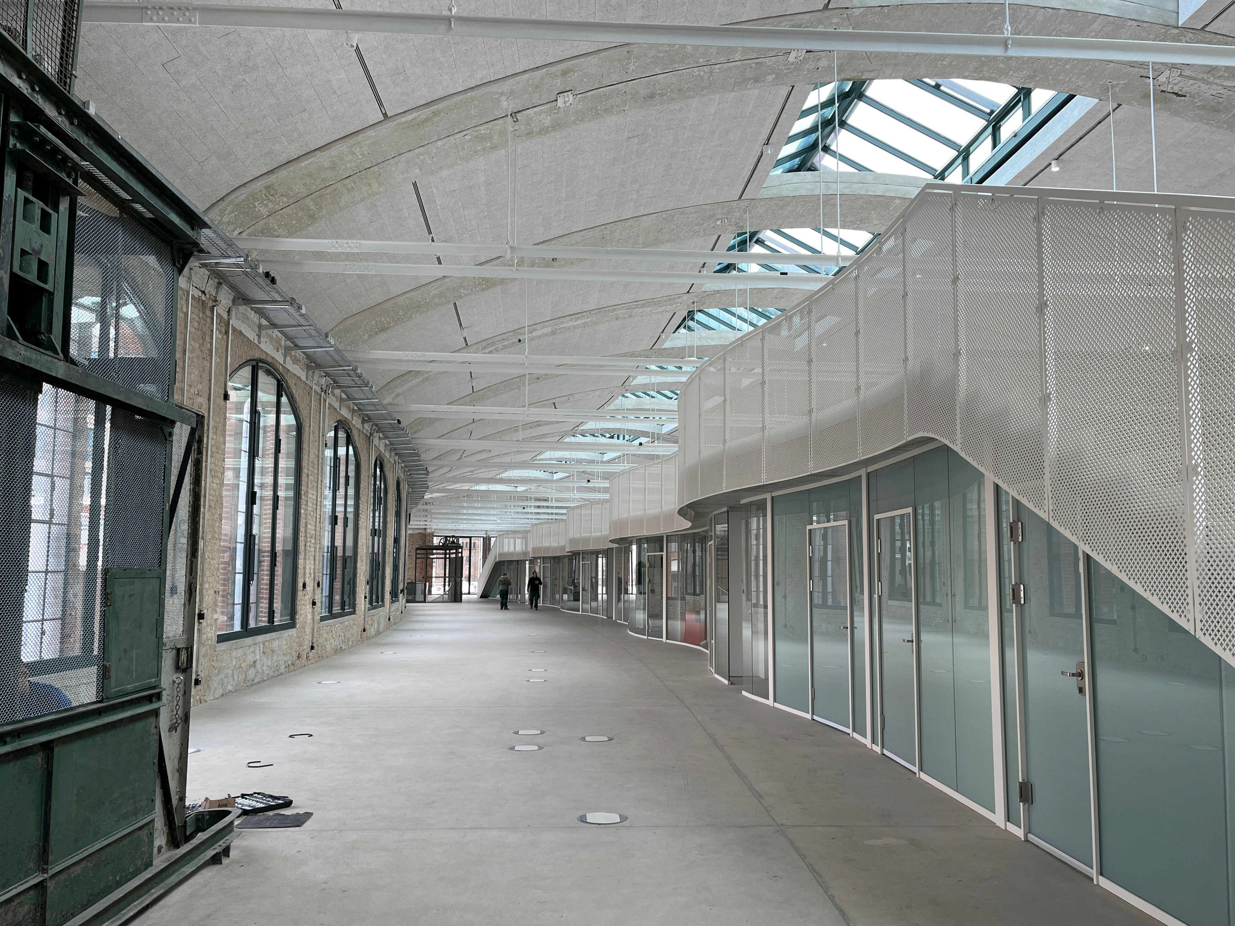 The image shows the construction progress at Postbahnhof Berlin featuring the gallery of the entrance packing hall with newly installed glass partitions along the interior façade.